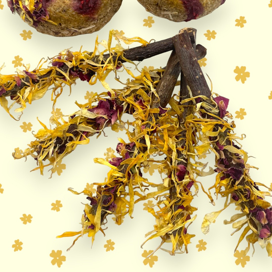 Candied apple sticks with mango pieces and petals of rose and marigold sprinkled on top, presented on a white background with decorative flower patterns.